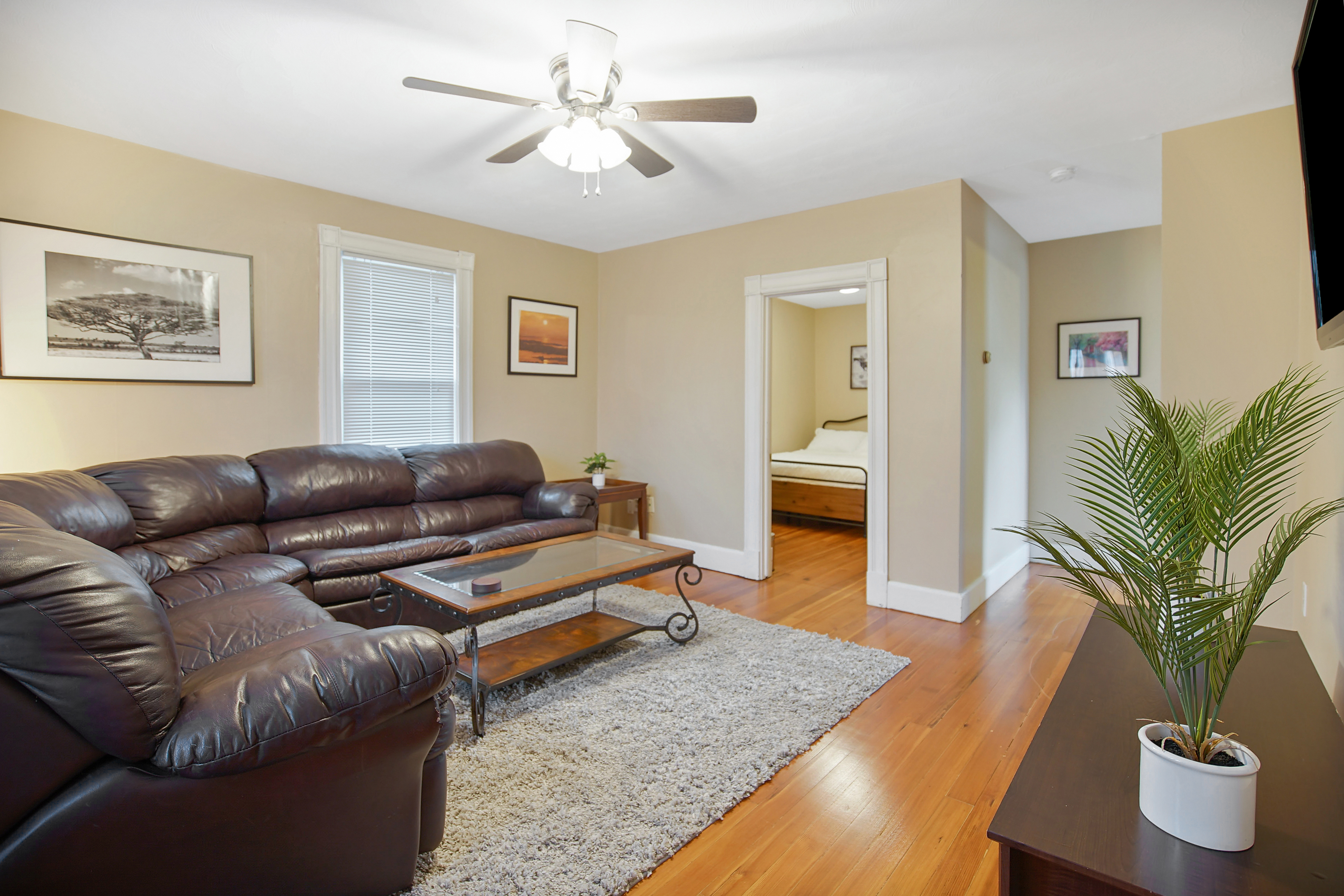 Oak Haven living room with sectional, hardwood floors, and bedroom view