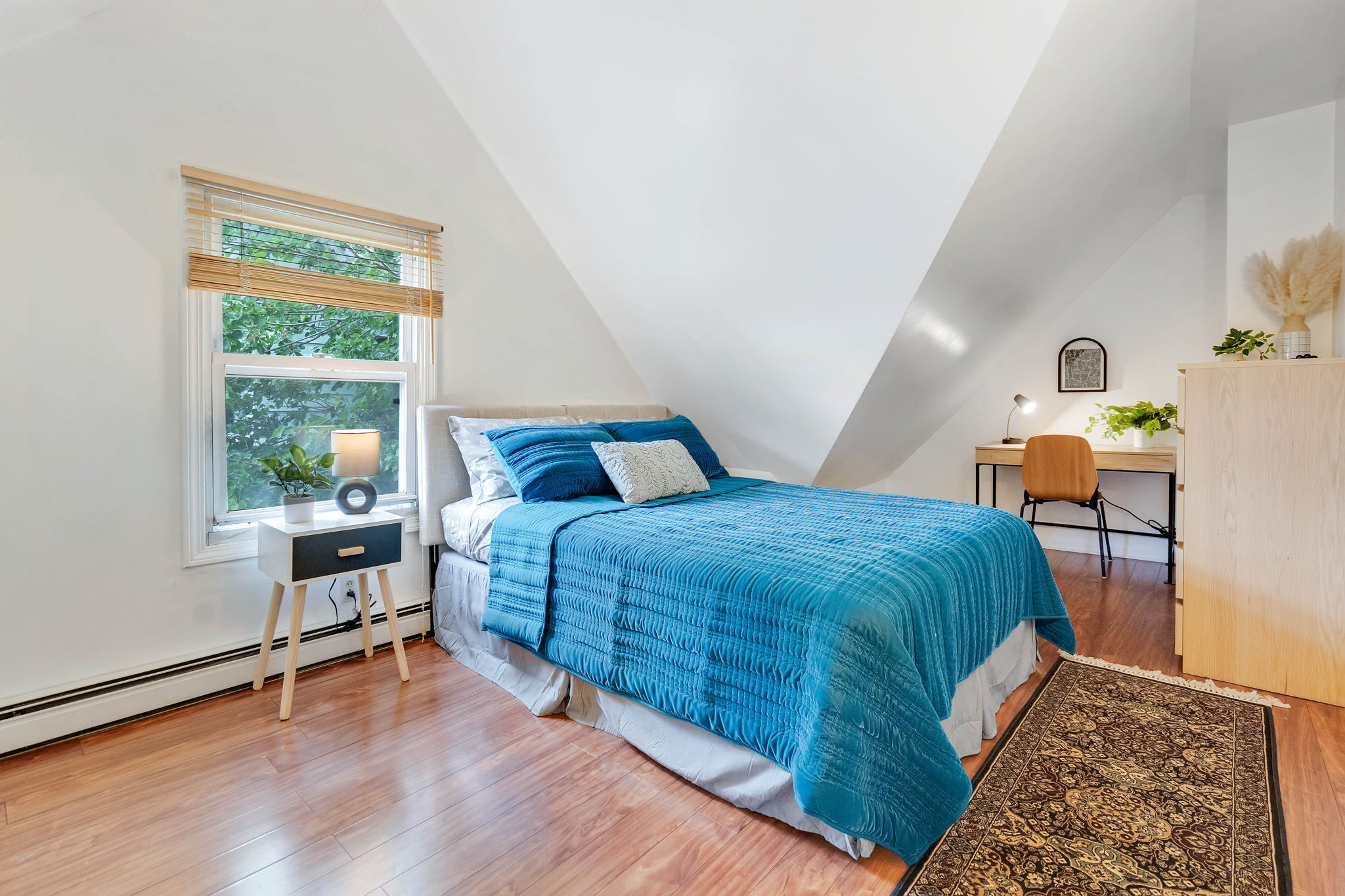 Bedroom with queen bed, hardwood floors, and corner desk